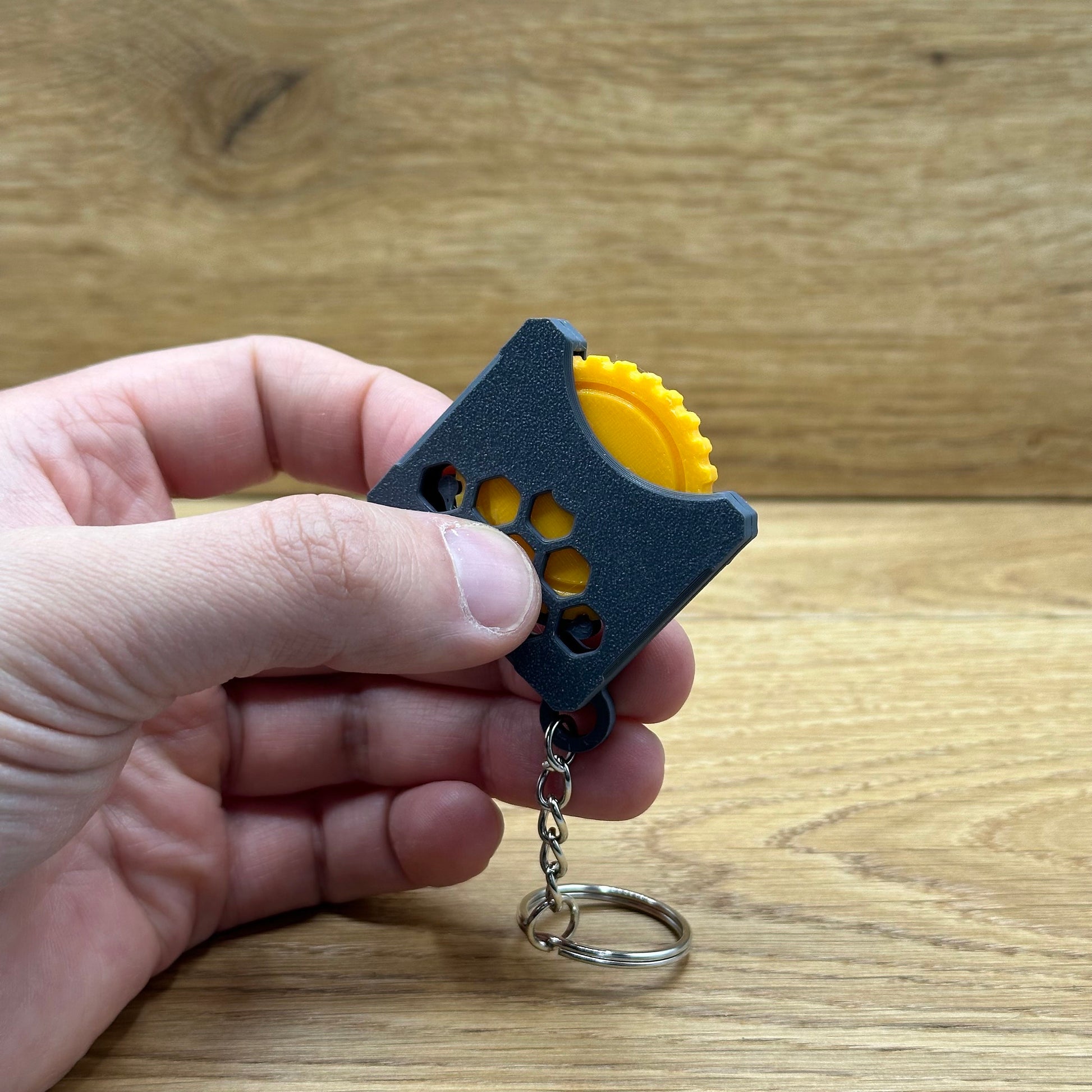 Stressspielzeug "Fidget Wheel" - Schlüsselanhänger mit Drehrad zum Stress reduzieren und rumspielen- Grau/Orange